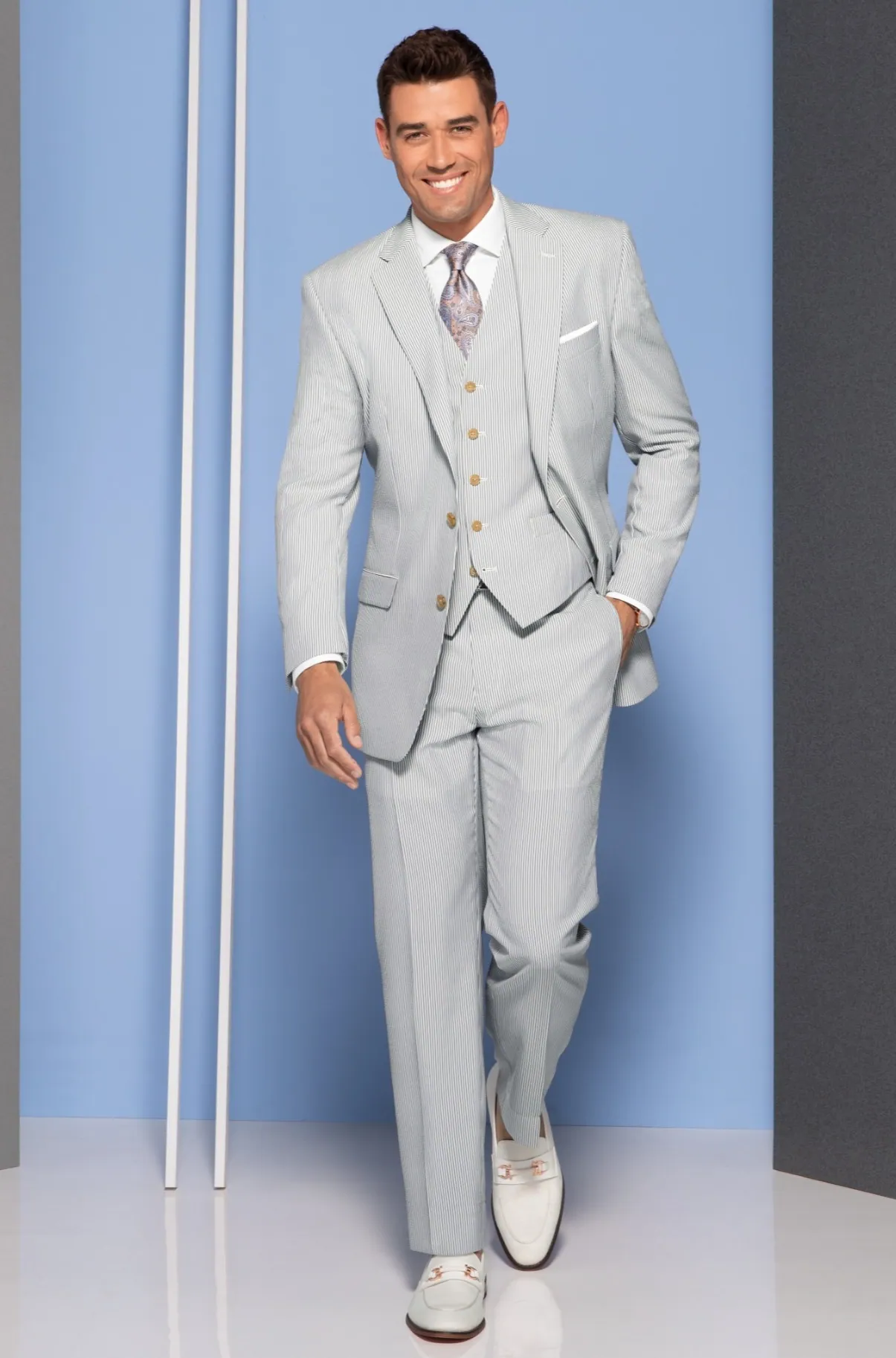 Model in a light gray suit against powder blue panels