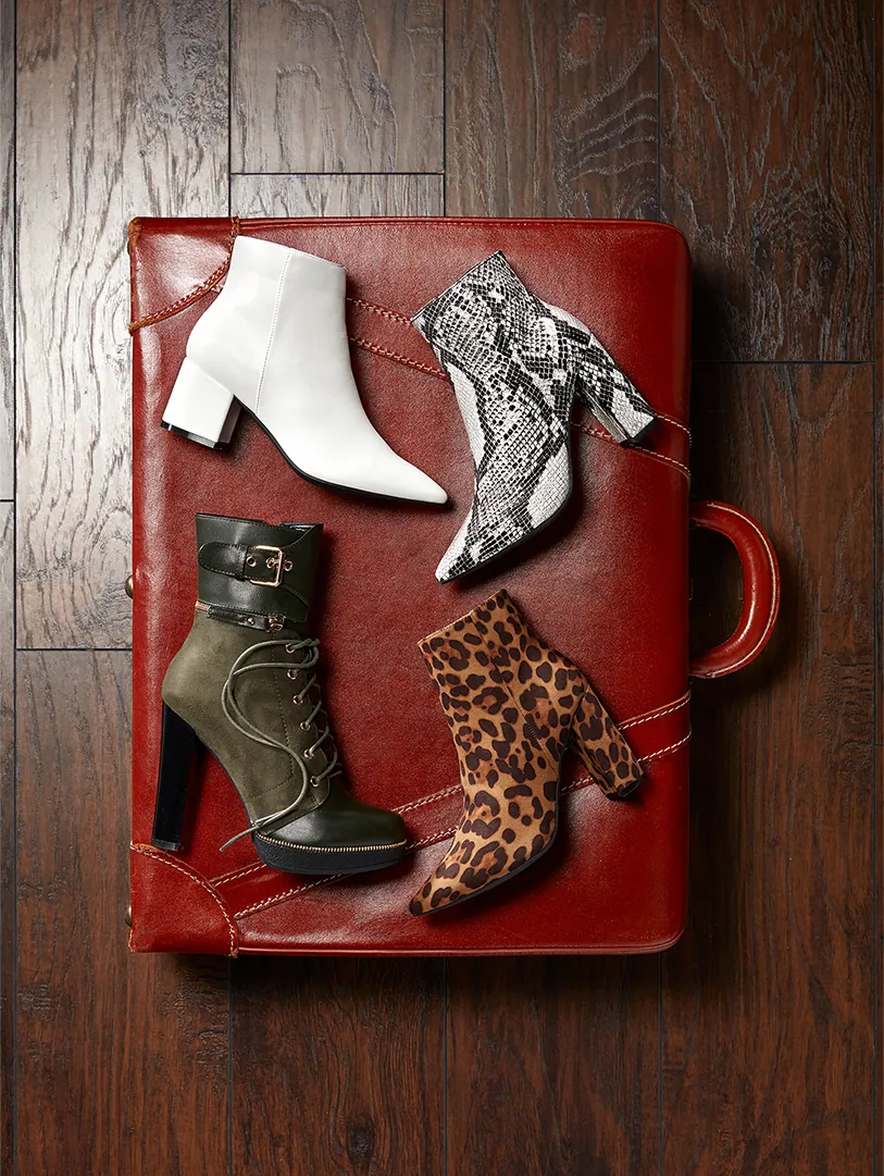 Still life of women’s boots on a red leather chair
