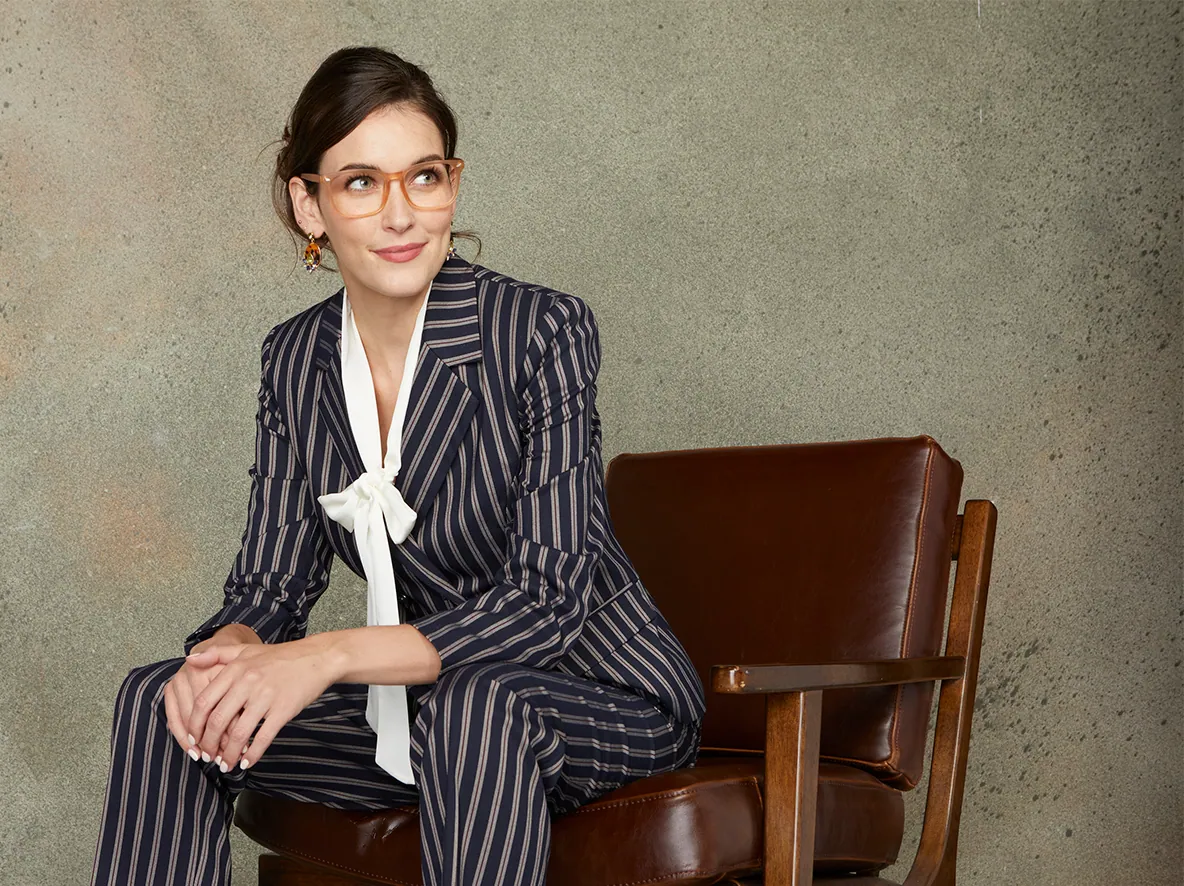 Model in a pinstripe suit seated in a leather chair