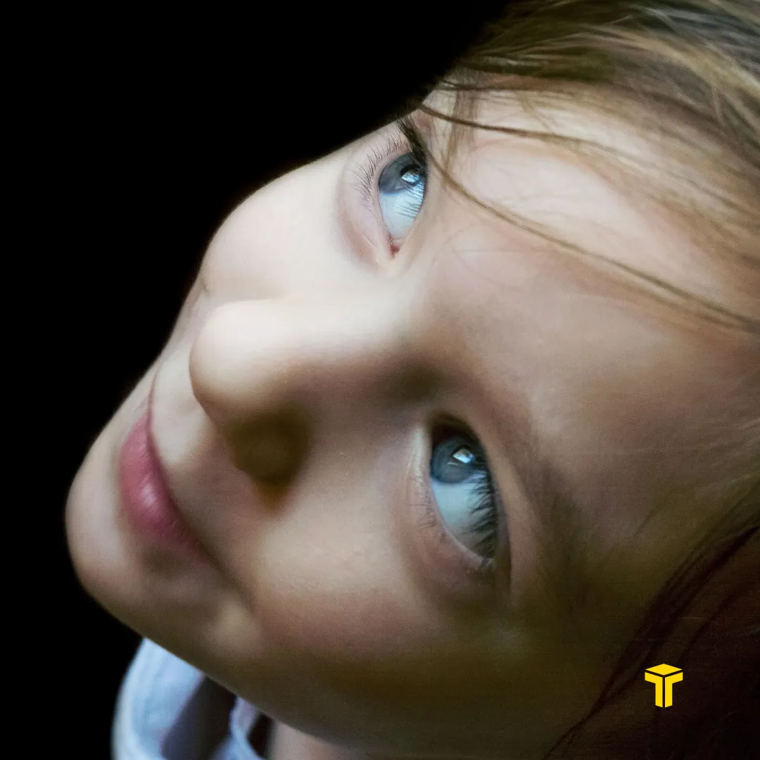Carousel slide two: a close portrait of a girl looking up