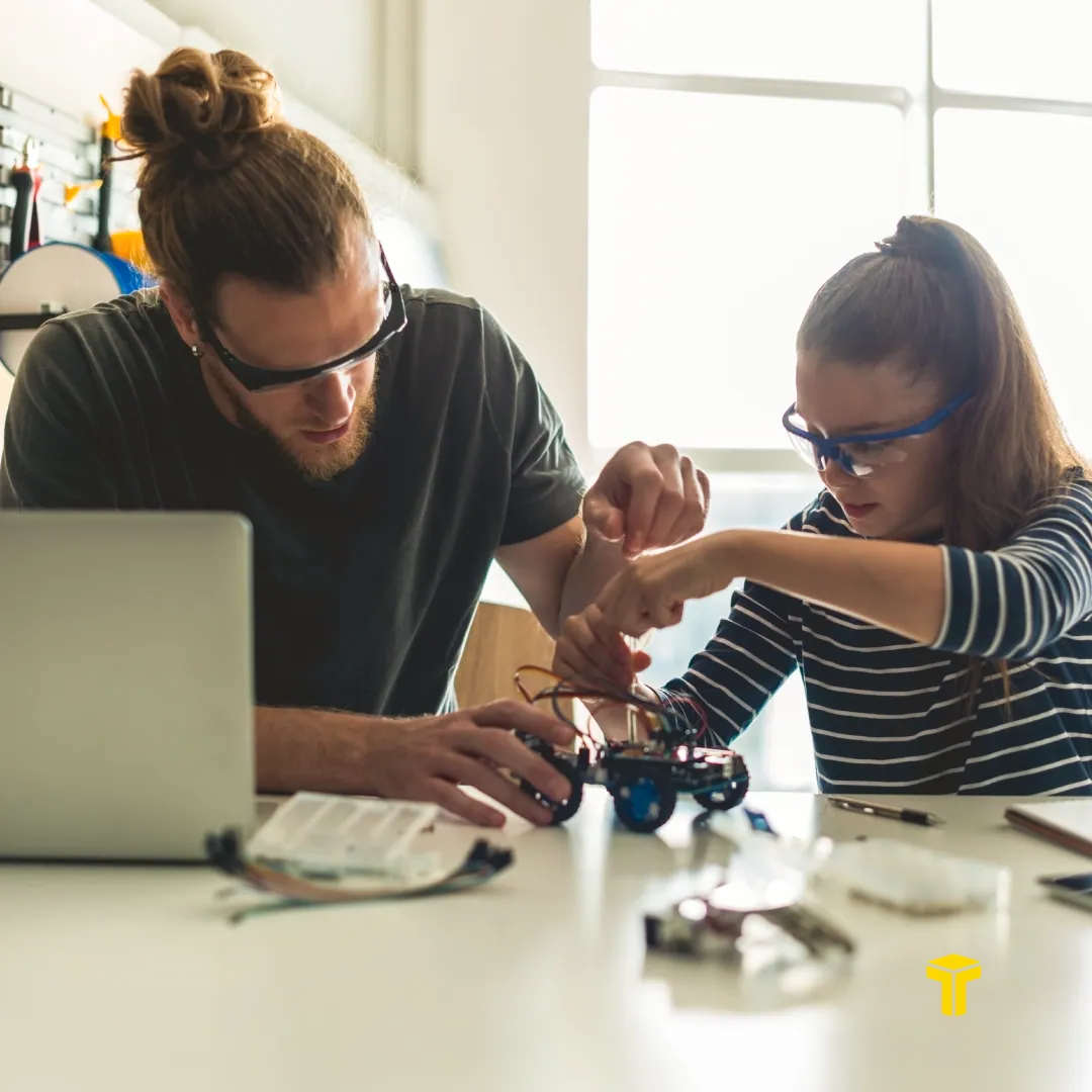 Carousel slide two: a student and teacher building a robot