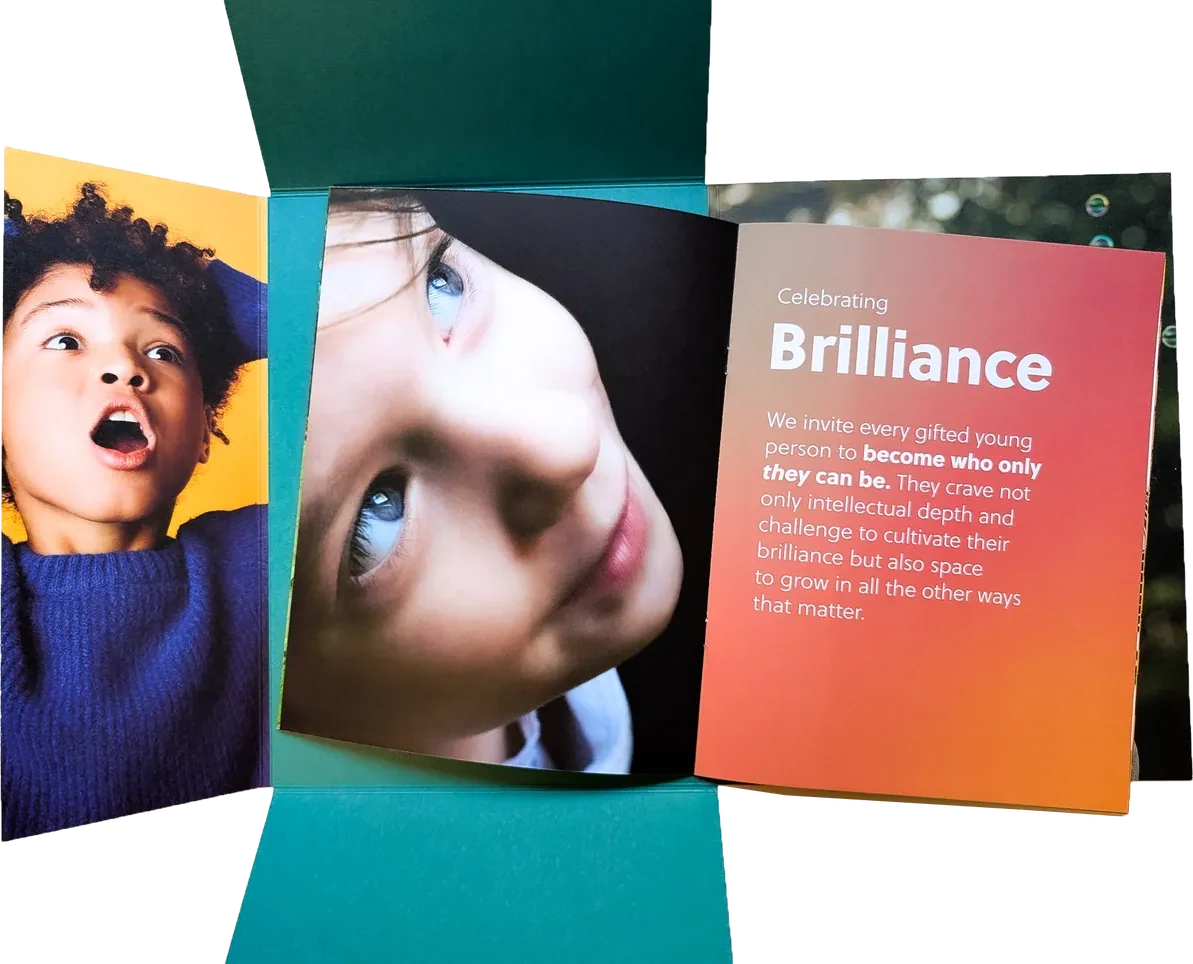 The printed folder open with the brochure lifted, showing the Celebrating Brilliance page on coral beside a close portrait