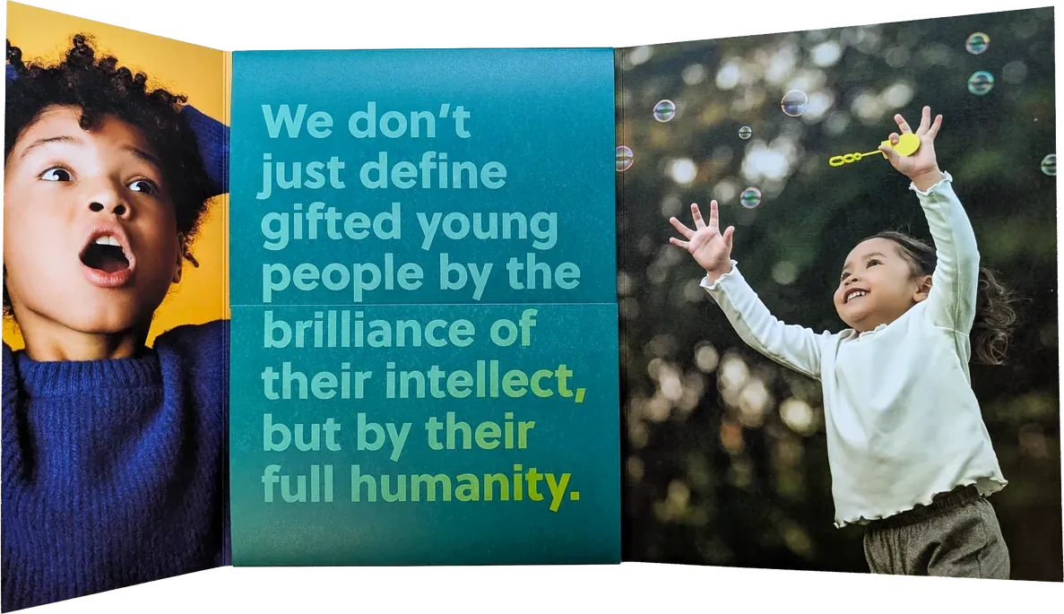 The printed folder open: a surprised child on yellow, the definition of giftedness in green type on a teal panel, and a girl reaching for bubbles